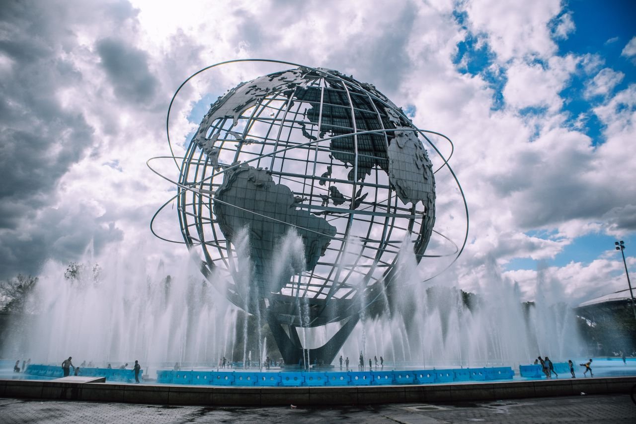the-story The iconic Unisphere monument in Flushing Meadows, New York, framed by a dynamic fountain display.